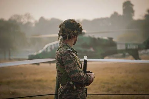 Army Attitude Shayari showing a lone Indian soldier standing alert near a military helicopter