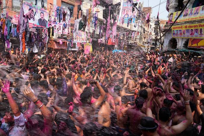 Holi Sad Shayari In Hindi showing a colorful Indian street celebration with people surrounded by Holi colors