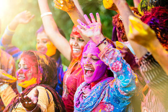 Holi Sad Shayari In Hindi showing people celebrating the festival with colored powders in an Indian setting