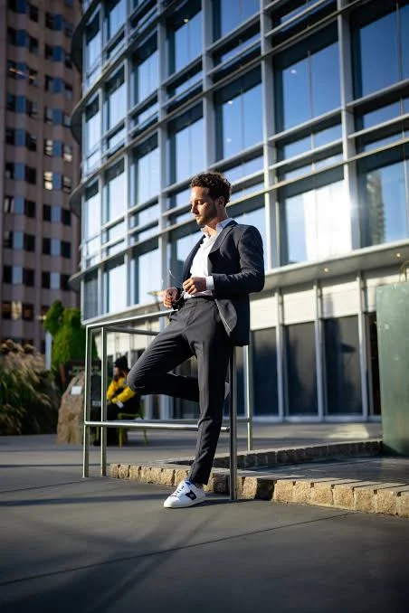 King Attitude Shayari In English showing a stylish man in a blue suit standing confidently on an urban street