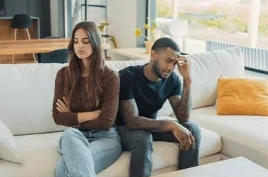 Sad Emotional Shayari In English showing a young couple sitting apart after an emotional relationship conflict