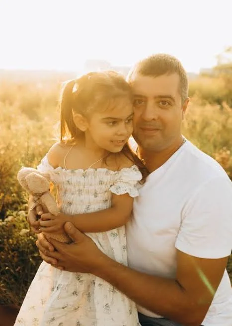 Papa Beti Shayari showing a father and daughter sharing a tender embrace outdoors in a sunny field