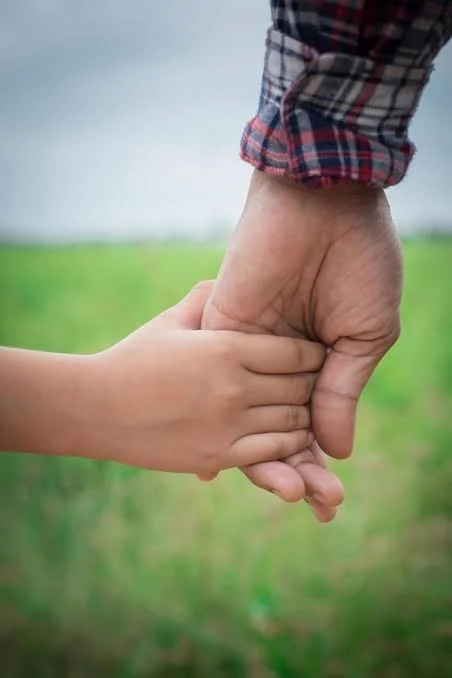 Papa Beti Shayari showing a close up of a father gently holding his daughter’s hand